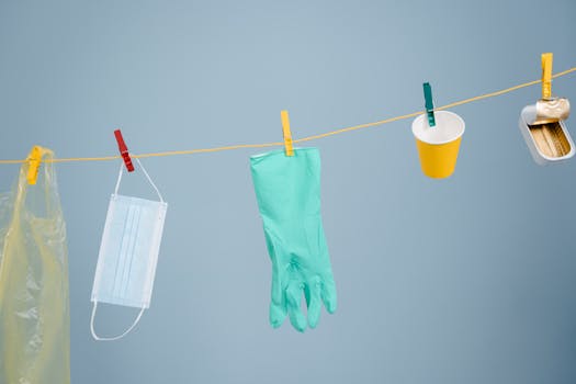 Hanging line with gloves, mask, and waste symbolizing recycling and environmental concerns.